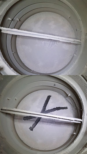 The exhaust vent screen when nearly fully clogged (above) and partially scraped clean (below)